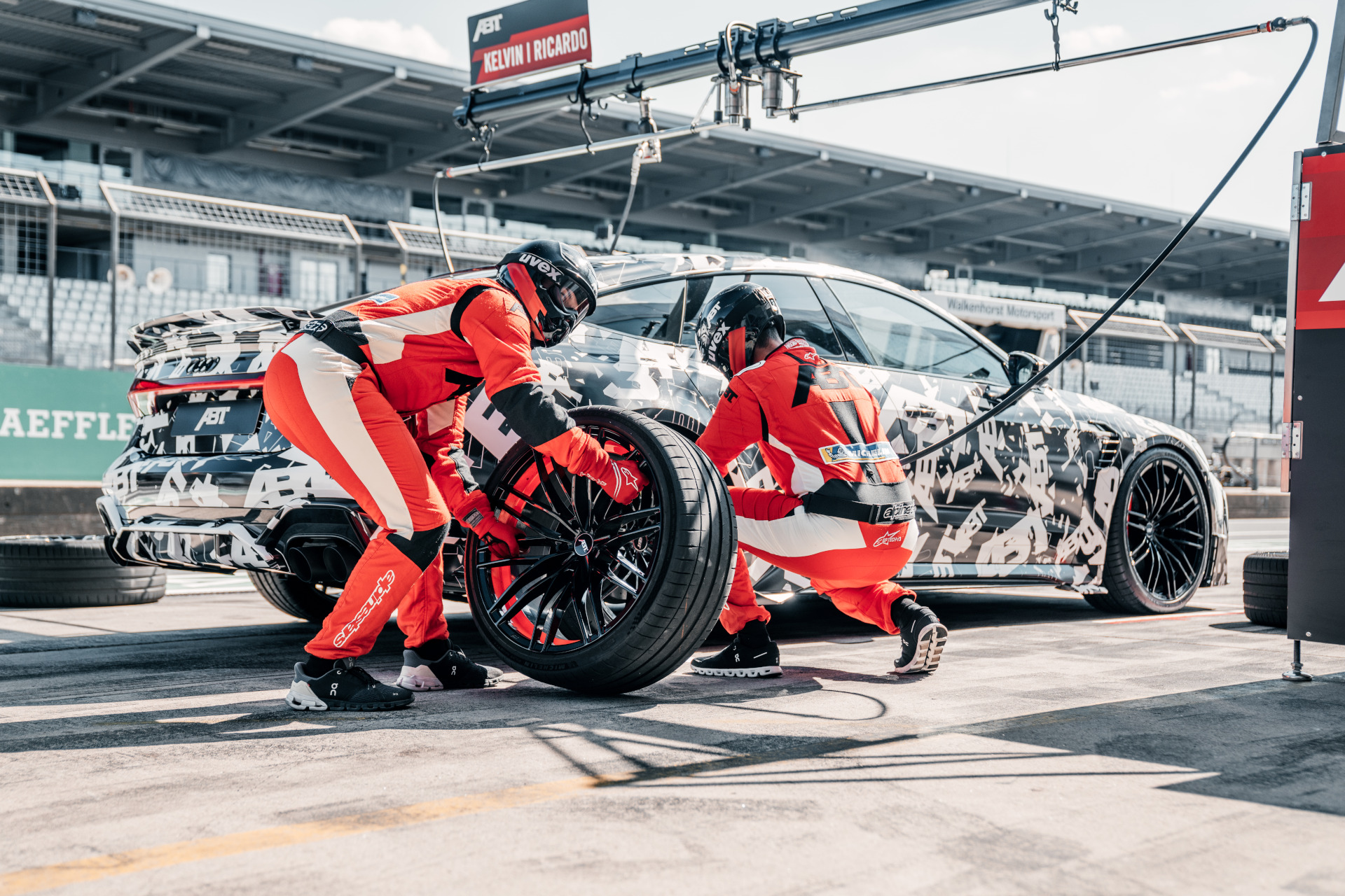 black, white RS7-LE-1000 PS changing tyres from the side view on the race track