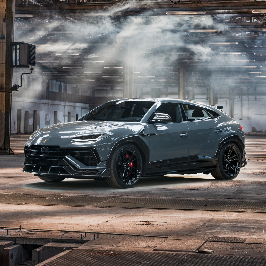 Blue-grey ABT Urus Scatenato from the side front view in a large warehouse 